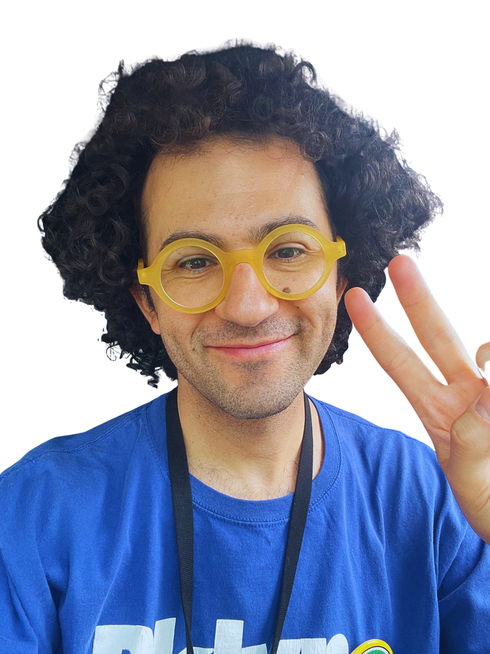 smiling person in yellow glasses flashing a peace sign